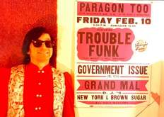 John Stabb of GI poses in front of show print, tags: Government Issue, Washington, D.C., United States, Gig Poster, Paragon II - Trouble Funk / Government Issue / Grand Mal on Feb 10, 1984 [017-small]